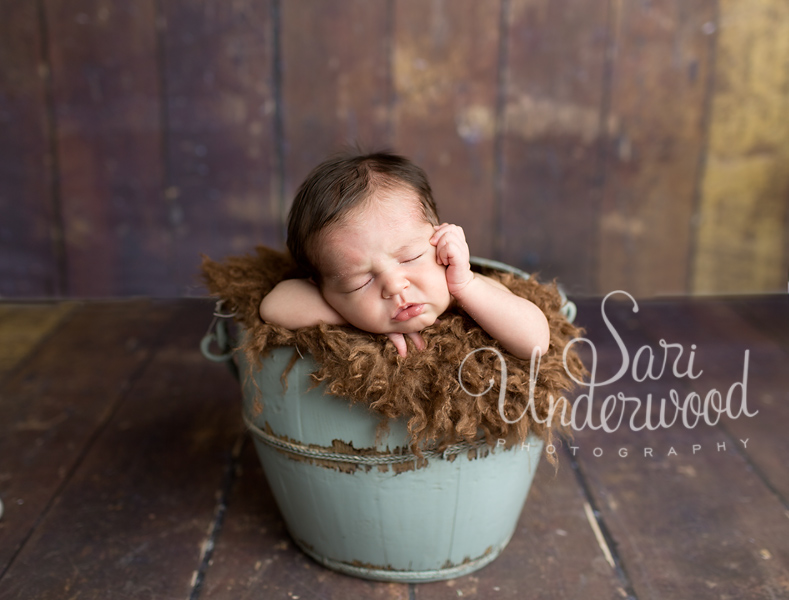 newborn boy posed in a bucket
