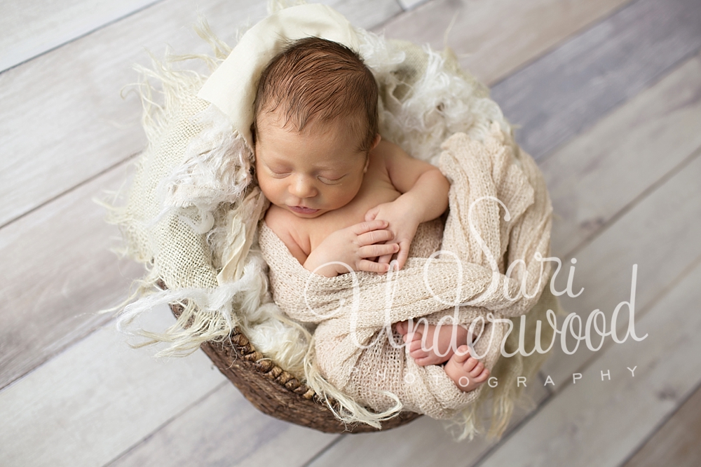 newborn baby boy cozy in a basket