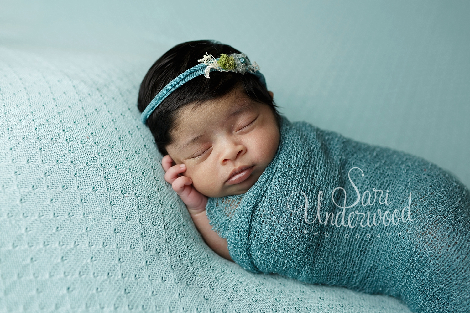 beautiful newborn baby girl in teal