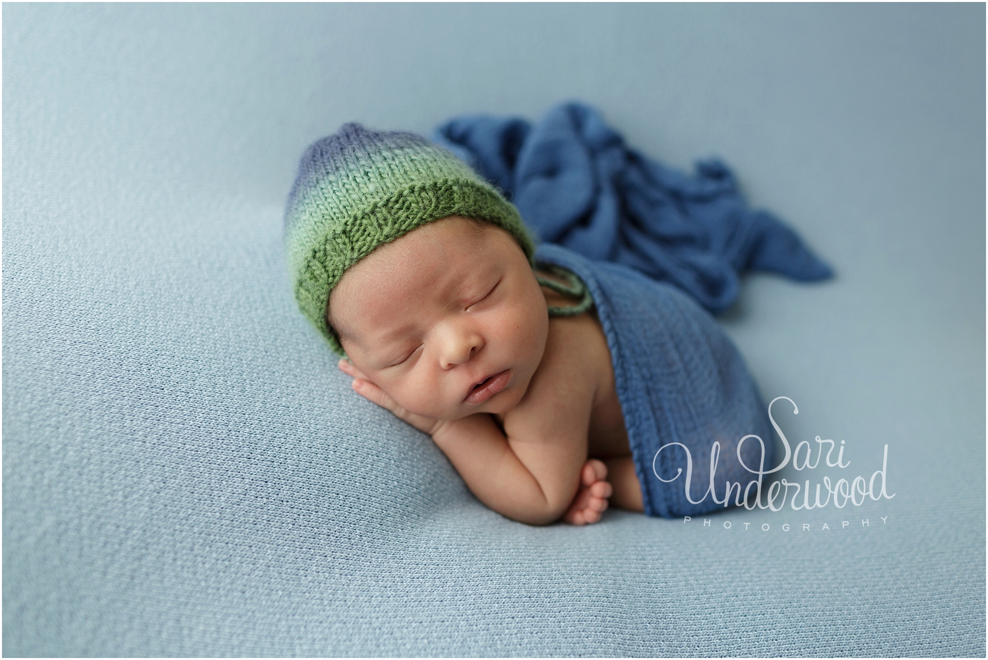 newborn baby boy in blue and green