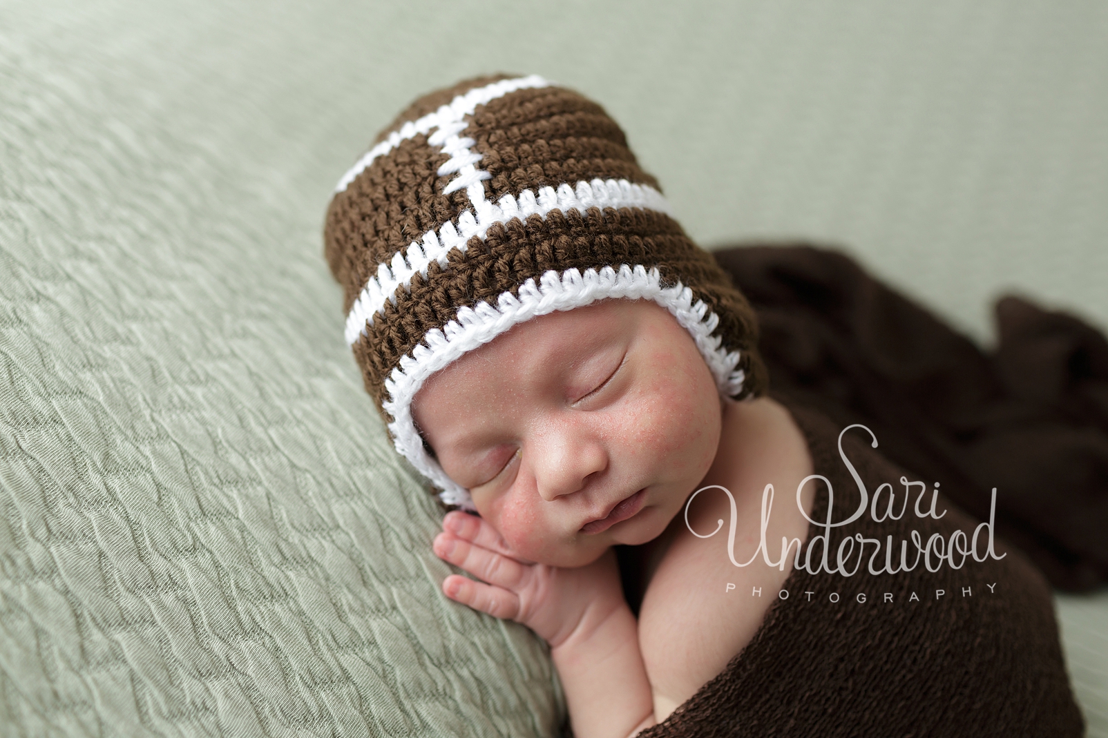 newborn baby boy in football hat