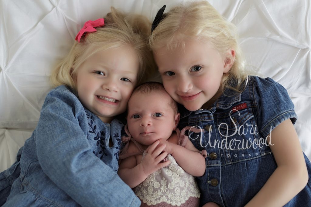 newborn baby girl with her two older sisters