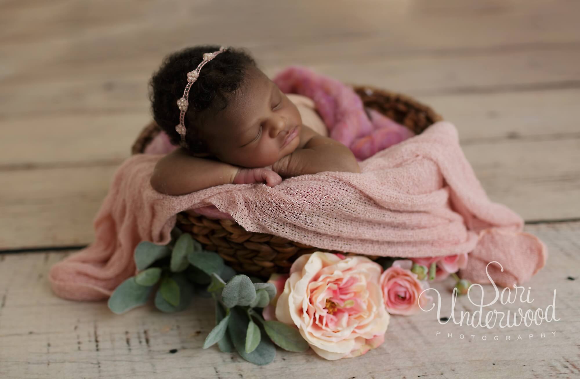 african american baby girl in a basket with flowers