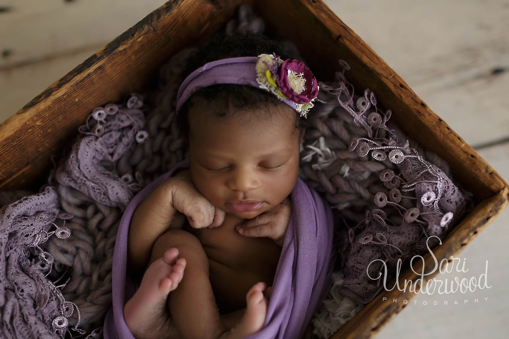 african american baby girl swaddled in purple