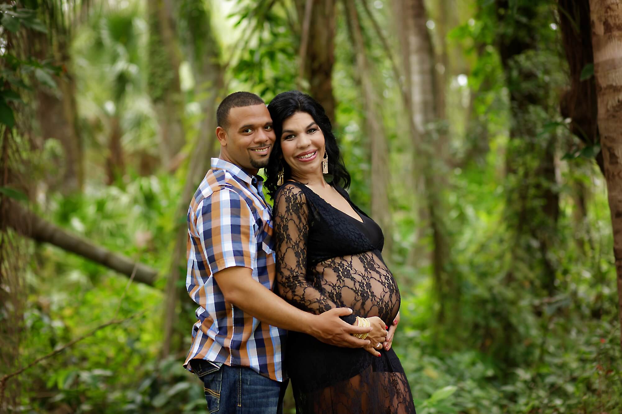 expectant parents posing outdoors