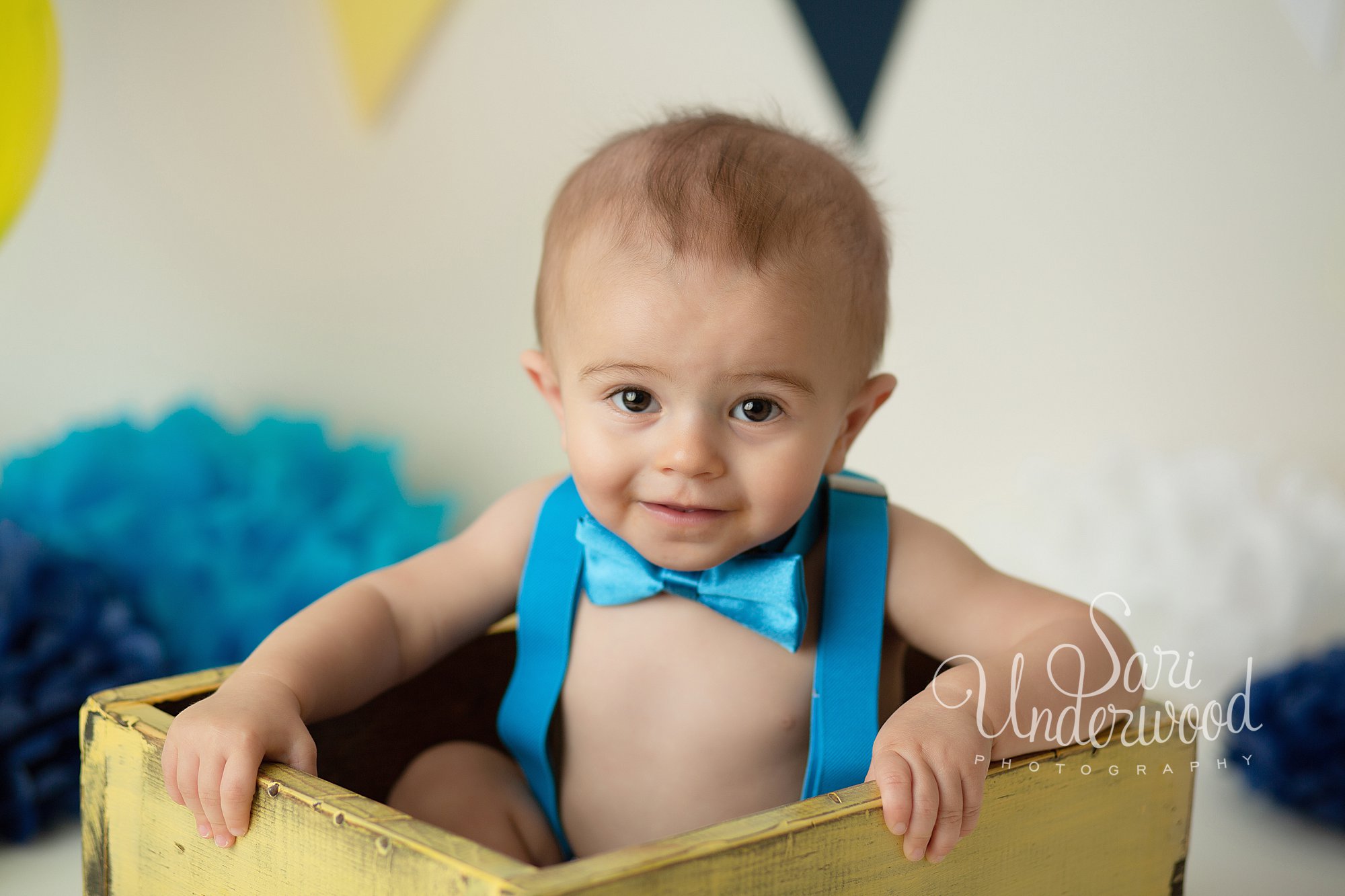 one year old baby boy sitting in a yellow box