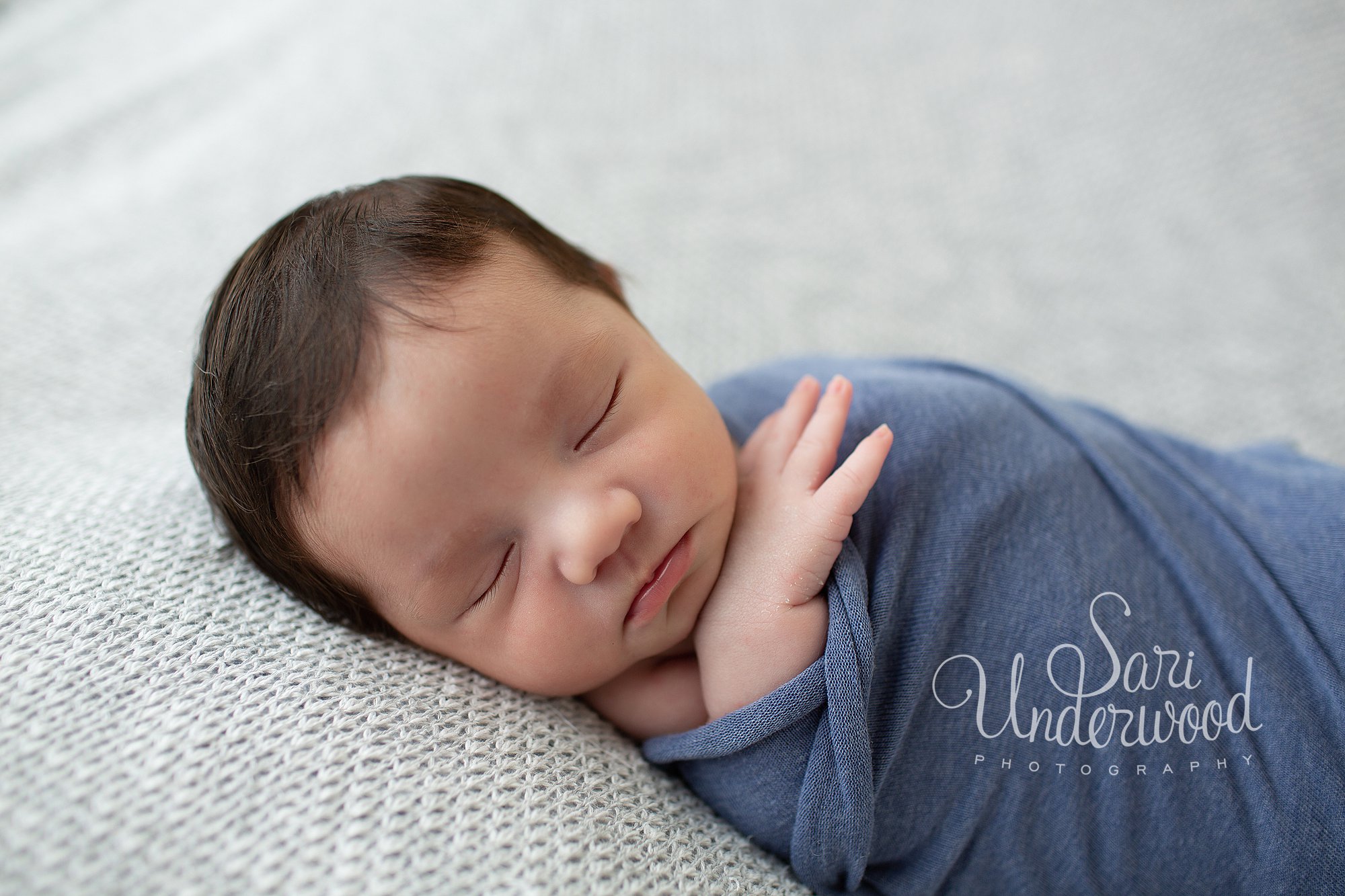 baby boy swaddled in blue