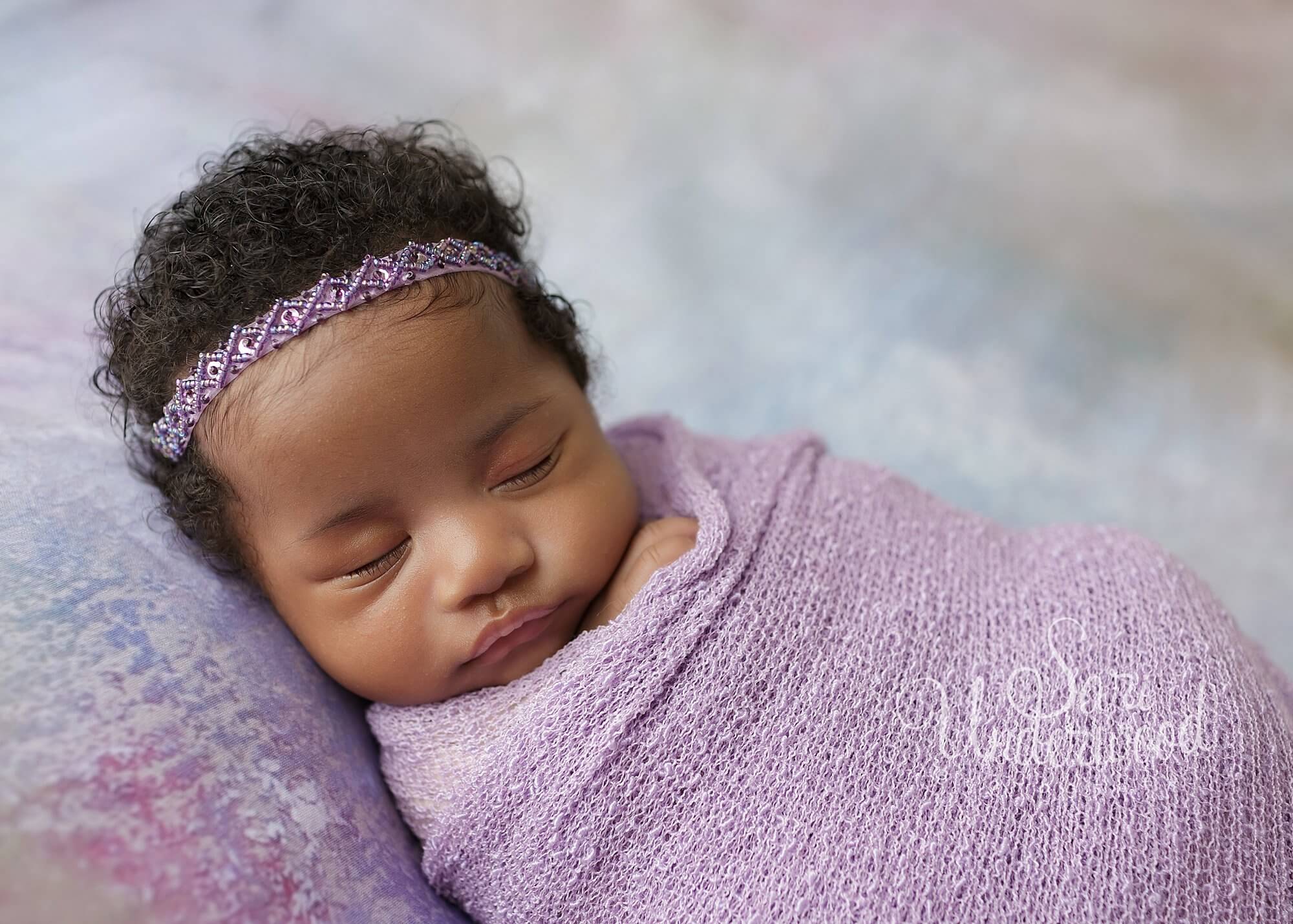 black baby girl swaddled in lavender wrap